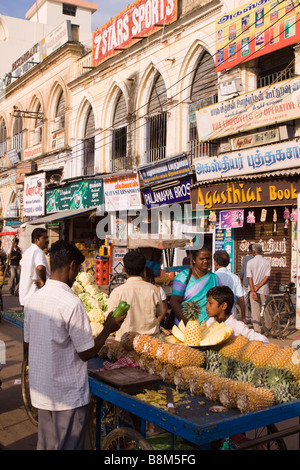 L'Inde Tamil Nadu Tiruchirappalli Chinnar Bazar boy looking at les tranches d'ananas sur market stall Banque D'Images