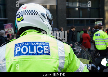 Ville de London Police agent moto avec les manifestants dans la ville de Londres Banque D'Images