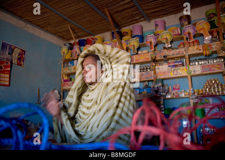 Fille arabe dans la boutique de vente est couvrant ses cheveux dans Banganarti près du Nil dans la région de Old Dongola, Nubie, Soudan Banque D'Images