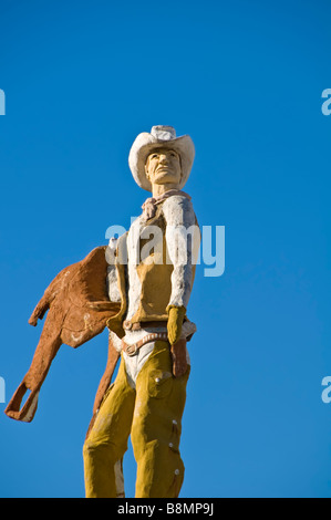 Statue de American Cowboy avec chapeau de cowboy cuir gilet holding selle avec fond de ciel bleu clair San Antonio Texas tx Banque D'Images