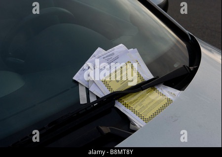 Les billets de parking s'entasser sur une voiture stationnée illégalement Banque D'Images