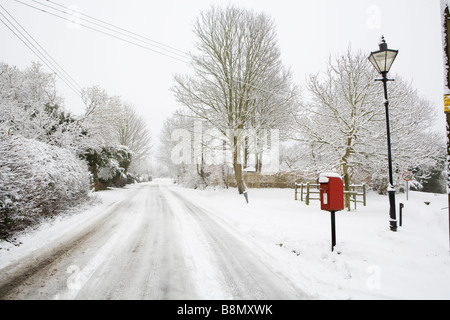 Royal Mail post box rouge et lampe de style traditionnel dans le village de Buckinghamshire couvertes de neige Askett. Banque D'Images