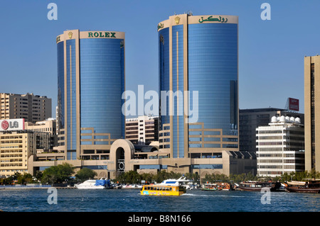 Bâtiment moderne de Dubaï Rolex annonce à l'horizon de l'architecture Twin Tower & Visite guidée d'amphibies rivière bateau bus Dubaï Creek EAU MOYEN ORIENT ASIE Banque D'Images