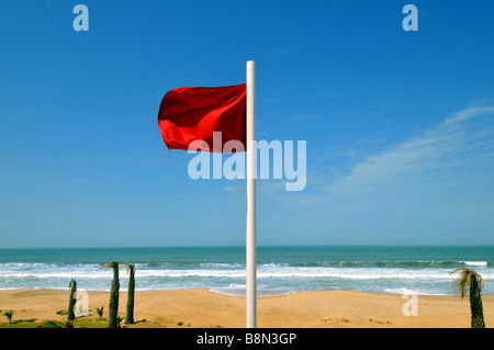 Drapeau rouge volant à une plage à ne pas entrer dans l'eau, de la Gambie, Afrique de l'Ouest Banque D'Images