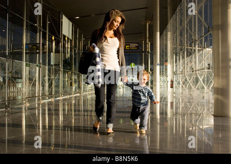 Jeune mère avec enfant en arrivant à l'aéroport européen Banque D'Images