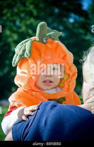 Mignon Bébé garçon dans un costume de citrouille étant tenu par sa grand-mère Banque D'Images