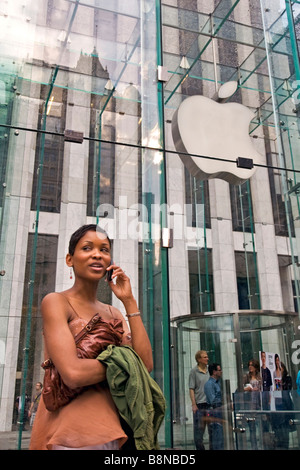 African American Woman parler sur son téléphone cellulaire à l'extérieur de l'Apple Mac store sur la 5e avenue Banque D'Images