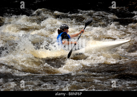 Un canoéiste négocie les rapides sur une rivière écossais Banque D'Images