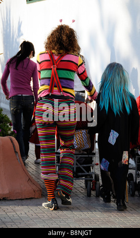 Femme portant un pantalon à rayures et le cavalier à marcher avec un enfant à la période de carnaval dans le sud de l'Espagne Andalousie Banque D'Images