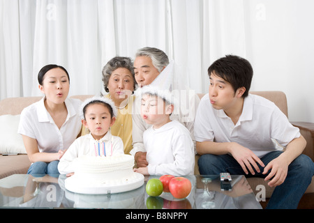 Family blowing birthday cake Banque D'Images
