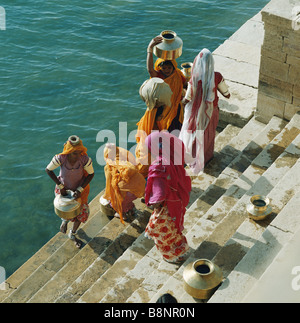 Les femmes indiennes à la collecte de l'eau du lac en Garisar Jaisalmer Rajasthan Inde Banque D'Images