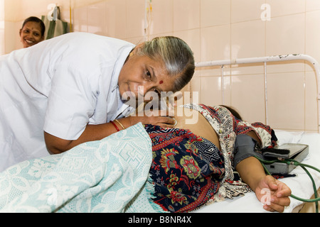 Infirmière de la maternité est à l'écoute / coeur de surveillance bébé à naître de la femme enceinte à la maternité de l'Hôpital Civil, Surat. Le Gujarat. L'Inde. Banque D'Images
