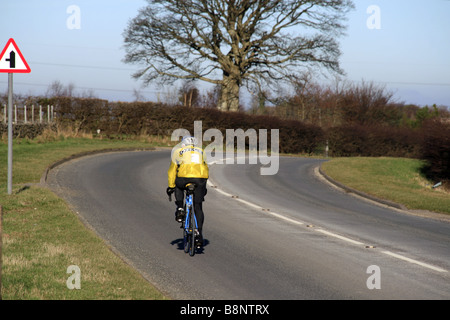 Un cycliste avec maillot jaune sur les routes de campagne au Pays de Galles, Royaume-Uni Banque D'Images