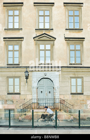 La Suède, Stockholm, bicyclist riding en face de l'immeuble Banque D'Images