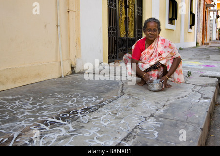 Inde Pondichéry woman decorating trottoir devant la porte avec l'eau du riz traditionnel modèle de nouvel an Banque D'Images