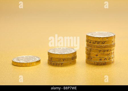 L'augmentation des piles de £1 pièces livre sterling sur un fond d'or Banque D'Images