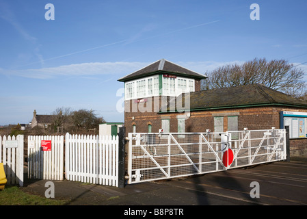 Ty Croes Anglesey au nord du Pays de Galles UK de passage à niveau avec barrières fermées par petite demande à arrêter la gare rurale Banque D'Images