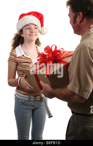 Une fille dans un Santa hat recevoir un cadeau par la poste l'accent sur fille isolée Banque D'Images