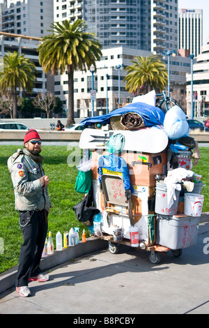 Homme debout sans-abri avec nos biens dans le panier dans Rincon Park à San Francisco en Californie pour demander de l'argent 'usage éditorial uniquement' Banque D'Images