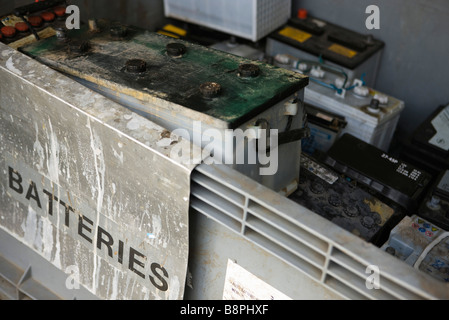 Vieille voiture batteries empilés dans bac de recyclage Banque D'Images