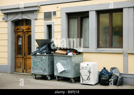 Poubelles débordant en face du bâtiment Banque D'Images