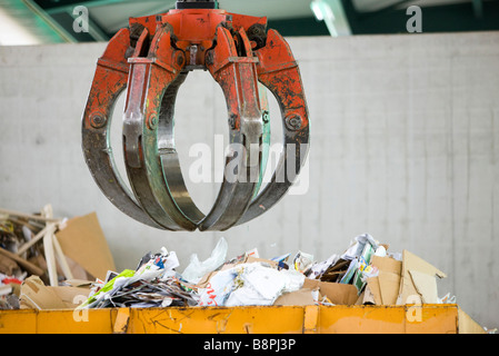 Suspendue au-dessus de la pince bin de déchets de papier in recycling center Banque D'Images