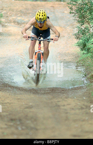 Équitation à travers cycliste flaque en vtt Banque D'Images