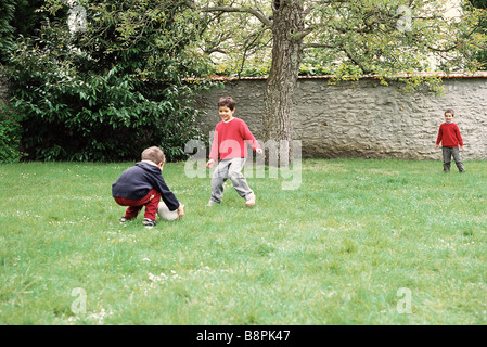 Boys Playing with ball in yard Banque D'Images