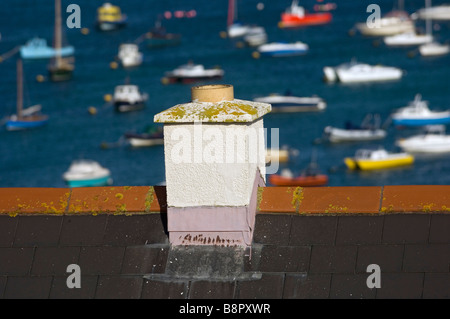 Bateaux amarrés dans le port de Hugh Town vue sur une cheminée sur le toit. St Mary's. Îles Scilly. Cornwall. L'Angleterre. UK Banque D'Images