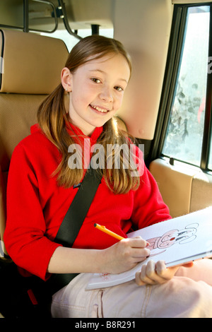 Souriant, heureux jeune fille s'amuse à l'arrière d'une voiture par le dessin et la coloration coloration Banque D'Images