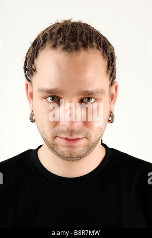 Portrait de jeune homme à tresses et boucles d'oreilles, studio shot Banque D'Images