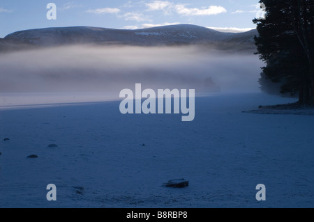 Mist rising over frozen Loch an Eilein Château Banque D'Images