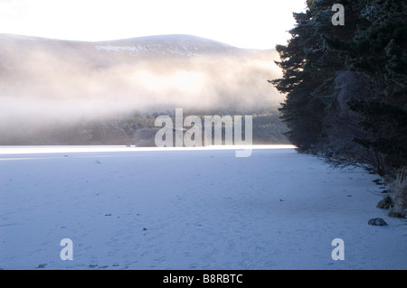 Mist rising over frozen Loch an Eilein Château Banque D'Images