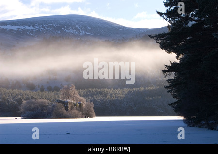 Mist rising over frozen Loch an Eilein Château Banque D'Images