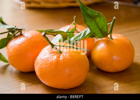 Quatre segments de mandarines sur une table en bois Banque D'Images