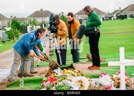 Équipe de tournage à fossoyeurs funérailles de Welsh Guards soldat vétéran de la guerre des Malouines, enterré dans un cimetière de Swansea Banque D'Images