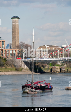 Bateau sur la Tamise avec Chelsea Bridge et shot tower en arrière-plan. London, England, UK Banque D'Images