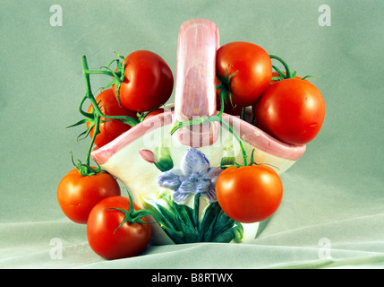 Les tomates disposées dans un vase en porcelaine vase en céramique, d'argile panier tomate rouge grappes imagerie artistique encore composition arrangement Banque D'Images