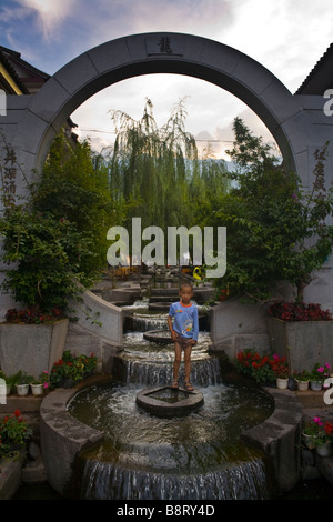 Un petit garçon joue dans une fontaine à Dali, Yunnan Province, China. Banque D'Images