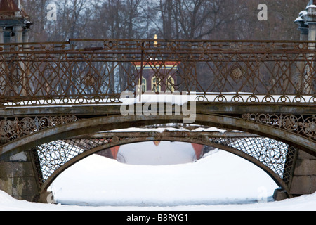 Métal patiné deux ponts en arc forgé recouvert de neige en hiver Parc. Banque D'Images