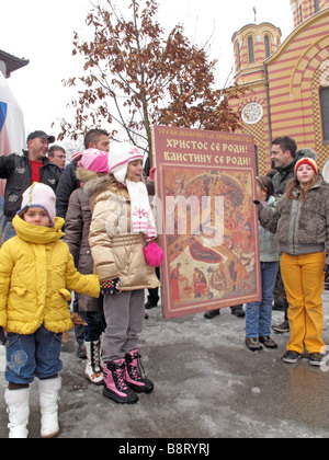 Les croyants et les enfants se rassemblent pour célébrer le "Badnjak" la veille de Noël Orthodoxe Banque D'Images