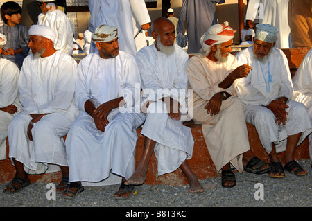 Groupe d'hommes omanais dans le costume national et une kummah Dishdasha cap ou d'un turban sur la tête mussar, Nizwa, Sultanat d'Oman Banque D'Images