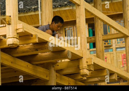 Un menuisier construction d'une maison en bois traditionnel, une près de Longshen, Guanxi, province de la Chine. Banque D'Images