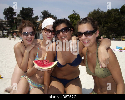 Quatre amies assis sur la plage, manger melon d'eau, de l'Espagne, Baléares, Majorque Banque D'Images