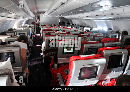 Cabine d'avion à jet d'Airbus Virgin Atlantic les passagers voyagent à bord d'un avion passager intérieur à bord d'un écran de film de divertissement TV à l'arrière des sièges Banque D'Images