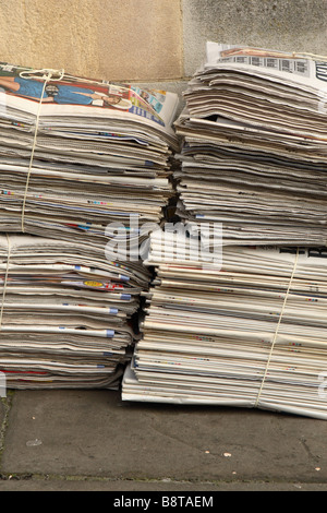 Pile pile de journaux dans un paquet sur le trottoir de la rue Banque D'Images