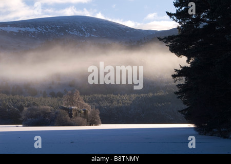 Mist rising over frozen Loch an Eilein Château Banque D'Images