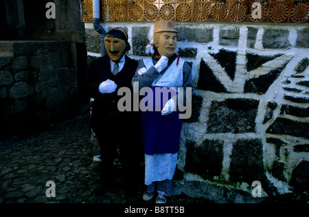 Deux villageois vêtu comme un couple de personnes âgées et portant des masques de bois étrange de prendre part à l'Caretos de Lazarim Carnaval festi Banque D'Images