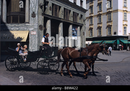Les touristes visiter Vienne en fiacre ou Horse & Carriage, en face d'Adolf Loos Haus ou House (1910), Vienne, Autriche Banque D'Images