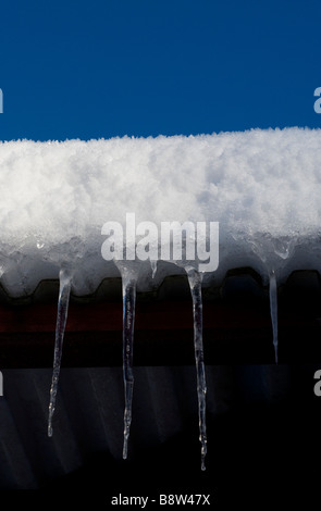 Les glaçons et la neige de toit en appentis Banque D'Images